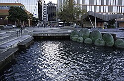The Kumutoto Stream's outlet (centre) into Wellington Harbour. To its right is Michel Tuffery's sculpture of kina shells.