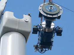 Components of a horizontal-axis wind turbine (gearbox, rotor shaft and brake assembly) being lifted into position