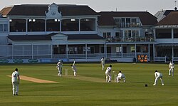 Photograph of St Lawrence Ground, showing a cricket patch taking place in the foreground and the pavilion behind