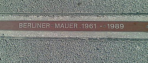 A "BERLINER MAUER 1961–1989" plaque near Checkpoint Charlie signifying where the Wall stood
