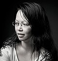 Young Asian woman with long black hair, white T-shirt and glasses, looking aside