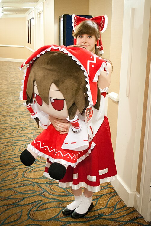File:Reimu Hakurei cosplayer and Reimu Fumo.jpg
