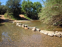 Stepping stone crossing next to a fording point on the river