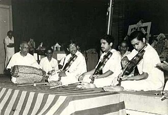 Carnatic music mridangam player Palghat Mani Iyer (left) at a concert with three violinists, from left to right: L. Vaidyanathan, L. Subramaniam, and L. Shankar.