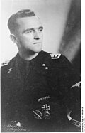 A man wearing a black military uniform and various military decorations.