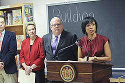 Angela Alsobrooks behind a podium and next to Larry Hogan