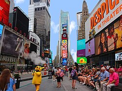 Times square with people sitting on a bench and a costumed character