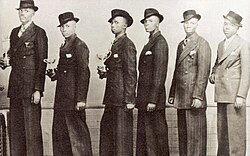 Photo of the Evening Birds taken in 1941 with Linda at the far left, shown standing in a straight line wearing matching striped suits, looking directly at the camera