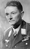 A man wearing a military uniform with an Iron Cross displayed at his neck.