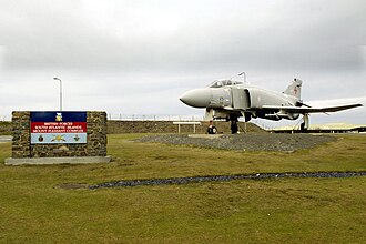 An F-4J Phantom II aircraft as the gate guardian at the entrance to the air terminal at Mount Pleasant Complex in the Falkland Islands. This was removed c. 2011