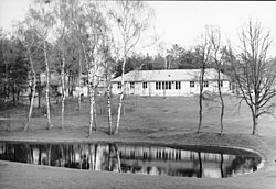 Rows of low dormitory buildings among trees
