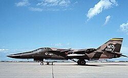 A swept-wing F-111A variable-geometry jet aircraft on a flight line at Mountain Home AFB
