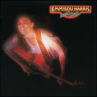 out-of-focus high-angle photo of Emmylou Harris on stage playing guitar with closed eyes and ecstatic look