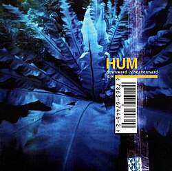 A photograph of leaves tinted blue with the word "HUM" written in gold and "DOWNWARD IS HEAVENWARD" below that in white. The cover has a large UPC code across it and a simulation of a sticker attached to it.