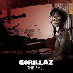 2-D of Gorillaz sits in a darkened room, turning his head to stare blankly at the viewer.