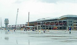 Jet bridges are being constructed from a partially complete terminal building.